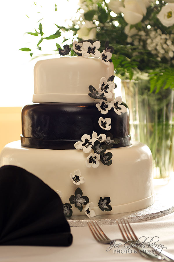 The wedding cake was a three tiered black and white cake with cascading flowers, prepared by White's Fine Cakes and Pastires.